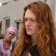 The red headed Marin Ireland as Nora in Y: the Last Man looks incredulous while her daughter, a woman in pink, and a horse stand behind her..